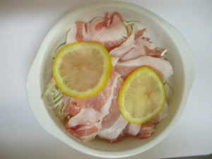 もやしを入れ、豚肉、レモンを重ねる。