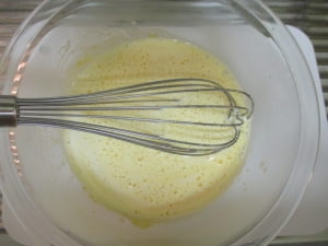 生クリームと牛乳を卵黄のボウルに入れて混ぜる