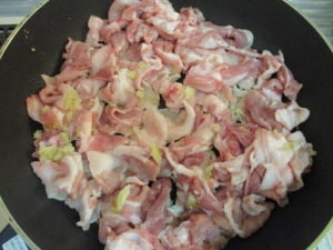 フライパンに豚肉を広げて、生姜を直接すりおろす。