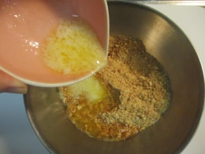 溶かしバターをビスケットに混ぜる。