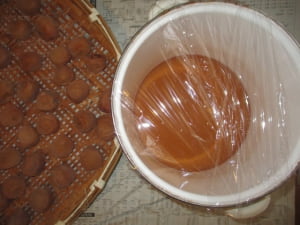 容器にラップをして、梅酢も日光に当てる。