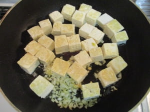 にんにくと豆腐を炒める。
