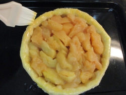 りんごを詰めて、パイの縁に溶き卵を塗る。