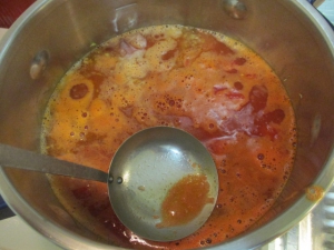 トマト缶と、水900ccを入れて沸かす。浮いてくるアクをとる