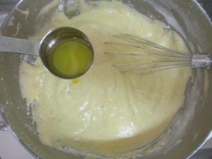 バターを大さじ１ぐらいずつ入れ、生地を泡立て器ですくって落とすようにして混ぜる。