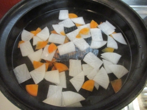 土鍋に水、昆布、大根、にんじんを入れて沸かす
