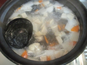 沸いたら鶏肉を入れて沸かし、アクをとる。鶏ガラスープと塩を入れる。